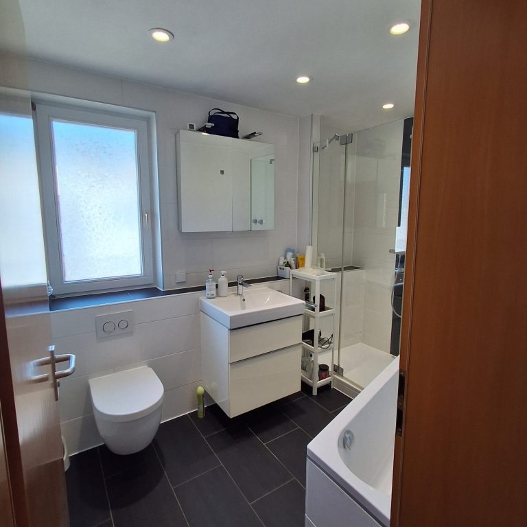 Bad Helles Badezimmer mit Dusche, Badewanne, Waschbecken und WC.