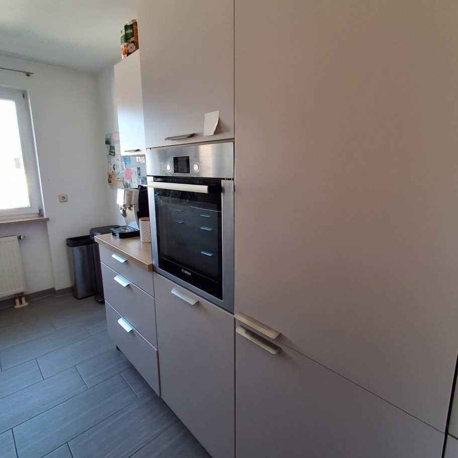 Küche Moderne Küche mit einem hellen Schrank und einem integrierten Backofen.
