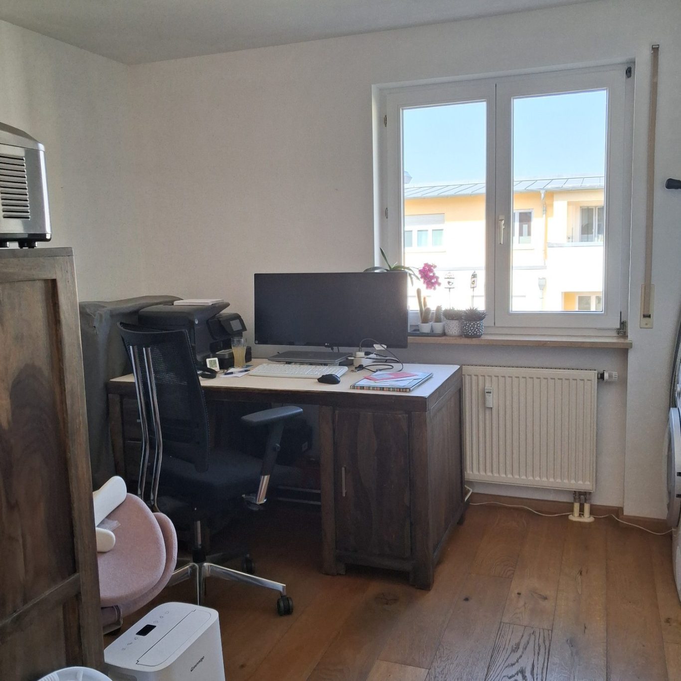 Arbeitszimmer Heller Arbeitsraum mit Schreibtisch, Computer und Fensterblick auf eine ruhige Straße.